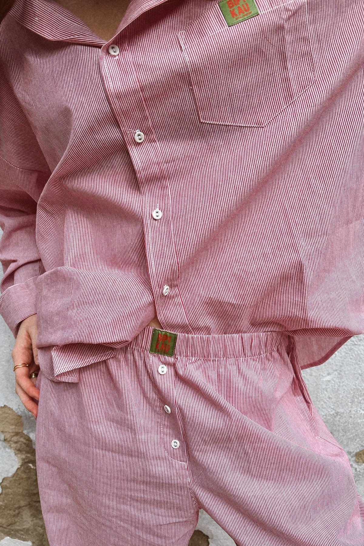 Soleil Set de Bipikau visto de cerca: camisa y pantalón de rayas rosas con botones y cintura con etiqueta