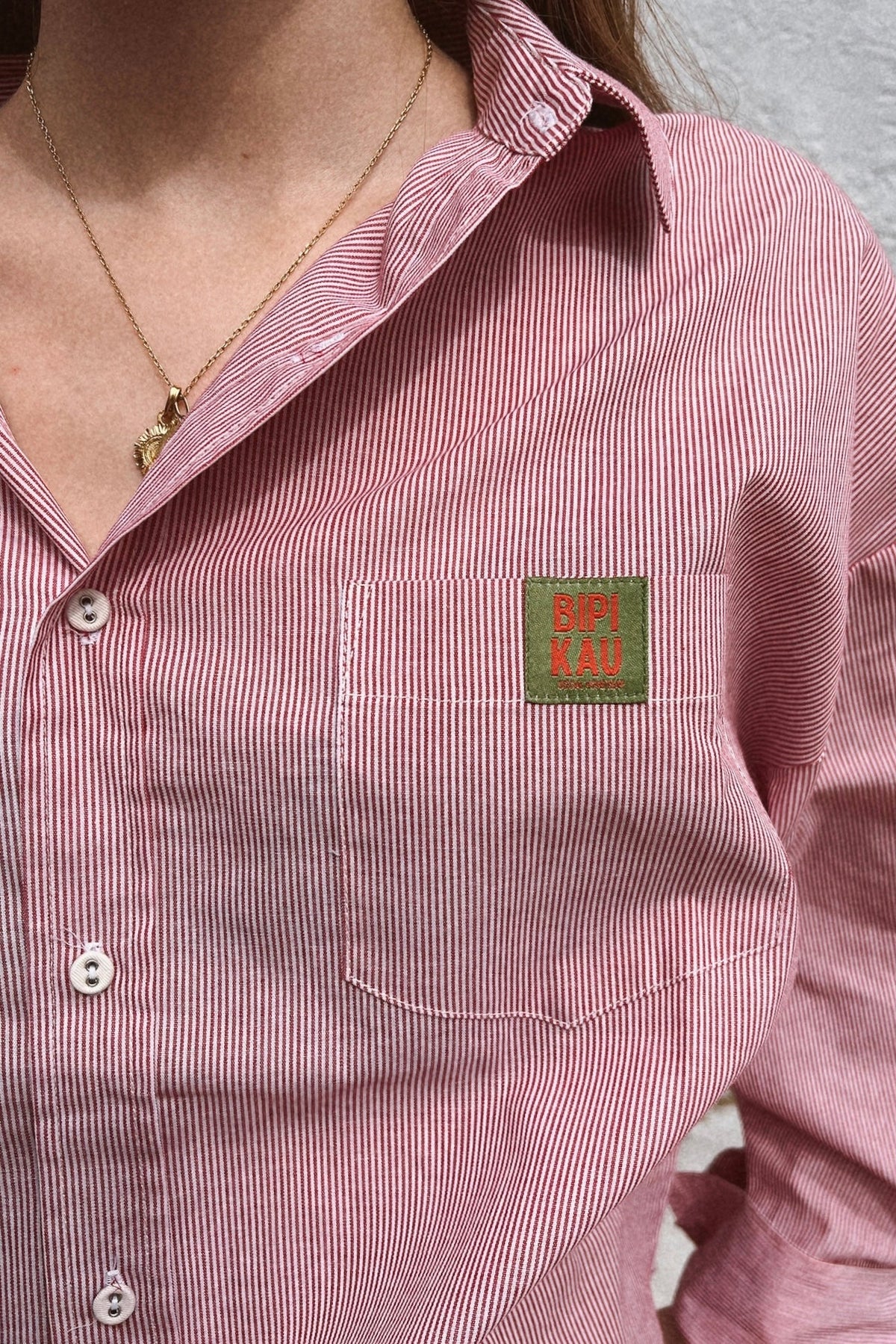 Detalle del bolsillo con la etiqueta bordada Bipikau en la camisa de rayas del Soleil Set