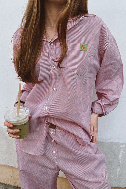 Soleil Set de Bipikau: conjunto de camisa oversize y pantalón fluido de rayas rosas, con un café en la mano