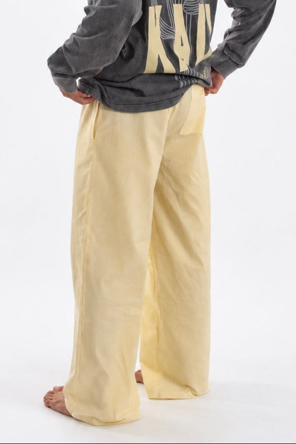 Sunset Pants Yellow de Bipikau de tres cuartos de espaldas: pantalón ancho amarillo claro de algodón