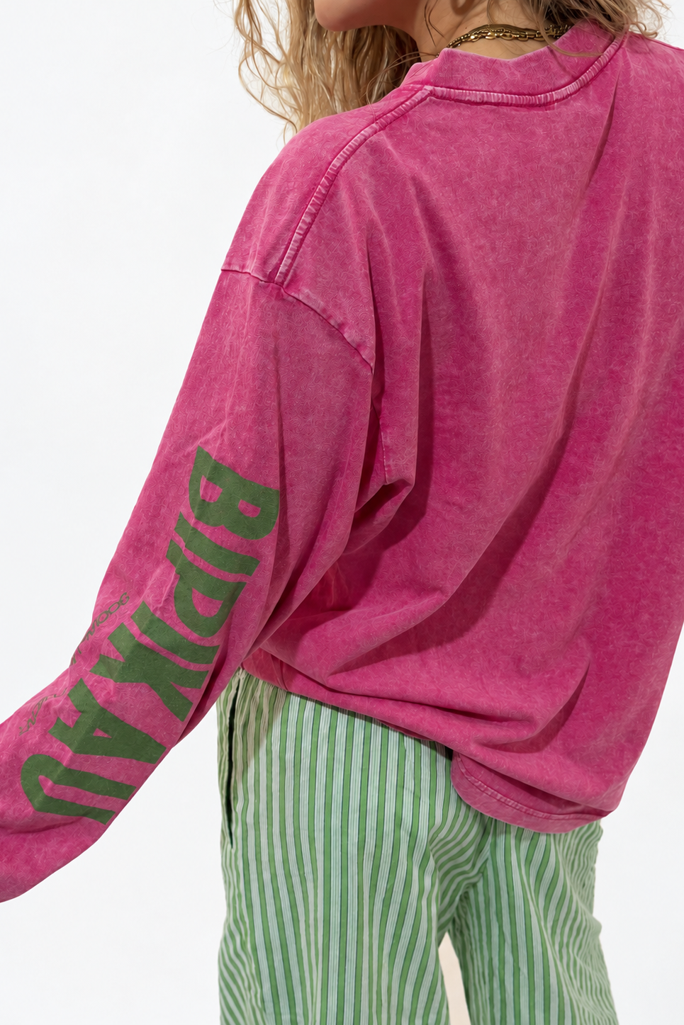 Hibiscus Tee de Bipikau: camiseta oversize de manga larga en fucsia lavado con el logo en la manga, con los Sunrise Pants de rayas verdes