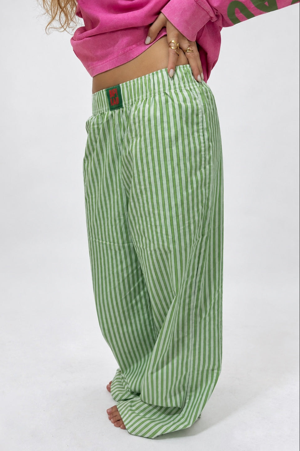 Sunrise Pants de Bipikau de perfil: pantalón ancho de rayas verdes de algodón con etiqueta en la cintura