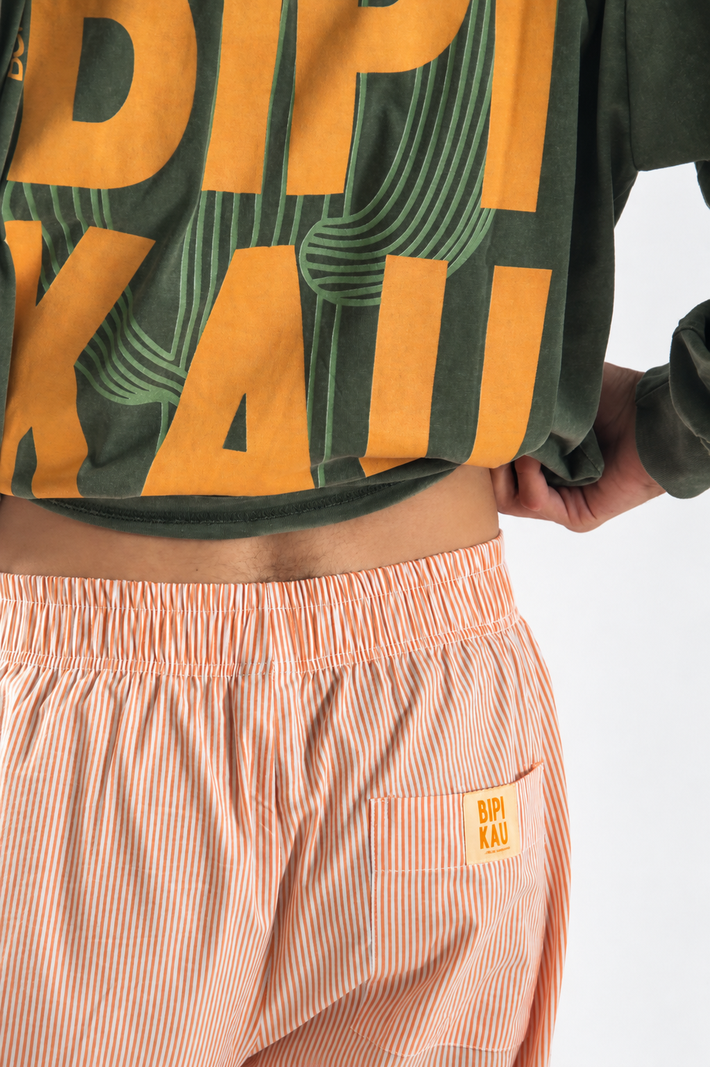 Detalle de la cintura elástica y la etiqueta Bipikau en el bolsillo trasero de los Sunset Pants Orange