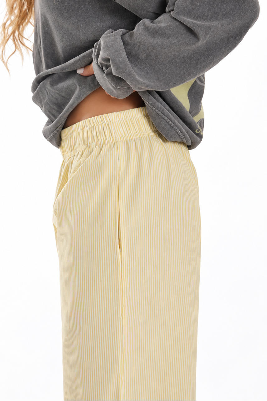 Detalle lateral de los Sunset Pants Yellow de Bipikau: cintura elástica y tejido de rayas amarillo claro