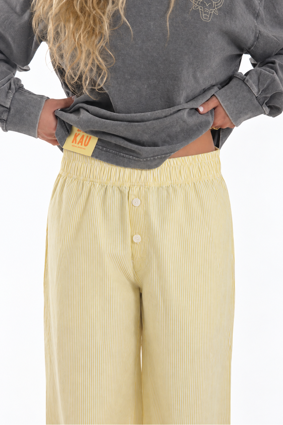 Sunset Pants Yellow de Bipikau de frente: pantalón de rayas amarillo claro con botones y etiqueta en la cintura